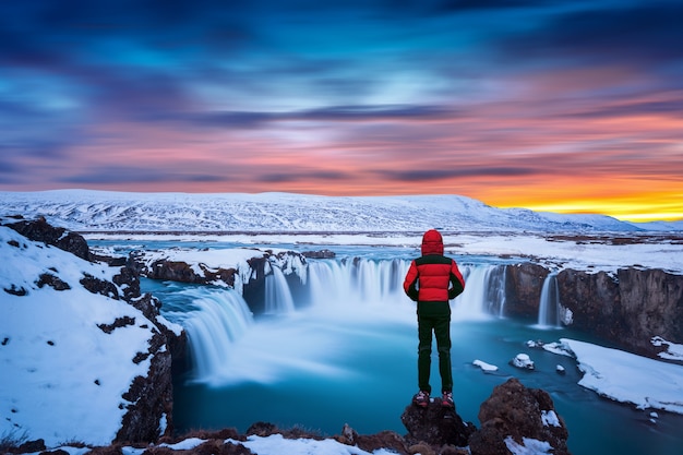 https://img.freepik.com/free-photo/godafoss-waterfall-sunset-winter-iceland-guy-red-jacket-looks-godafoss-waterfall_335224-673.jpg